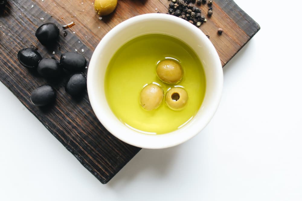 aceite de oliva bowl con aceite y aceitunas de color negra y verde