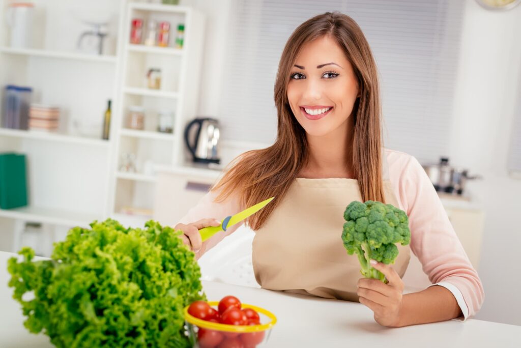 Mujer hermosa preparando ensalada con brocoli