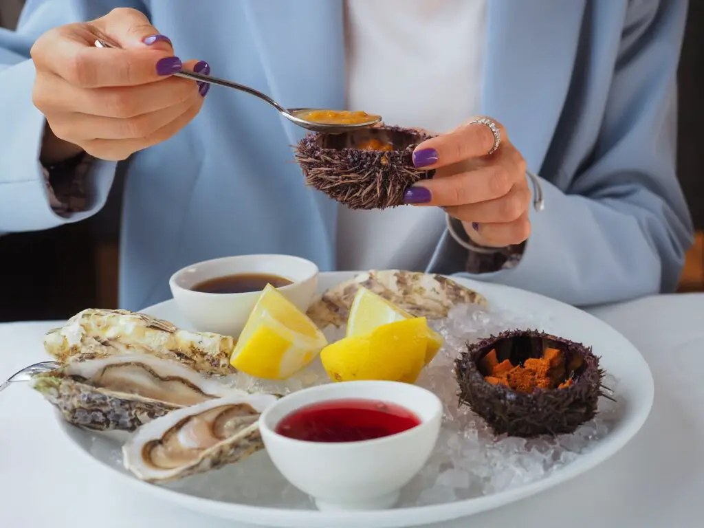alimentos ricos rn zinc mujer comiendo ostras