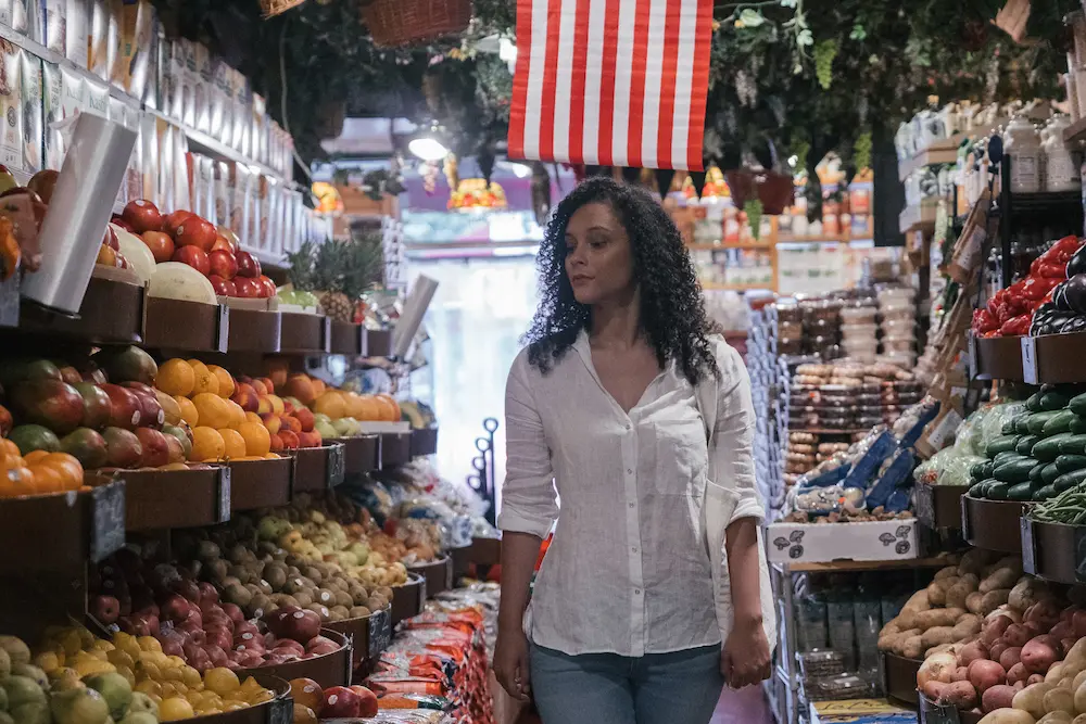 fruta con fibra mujer caminando en supermarket en zona de frutas