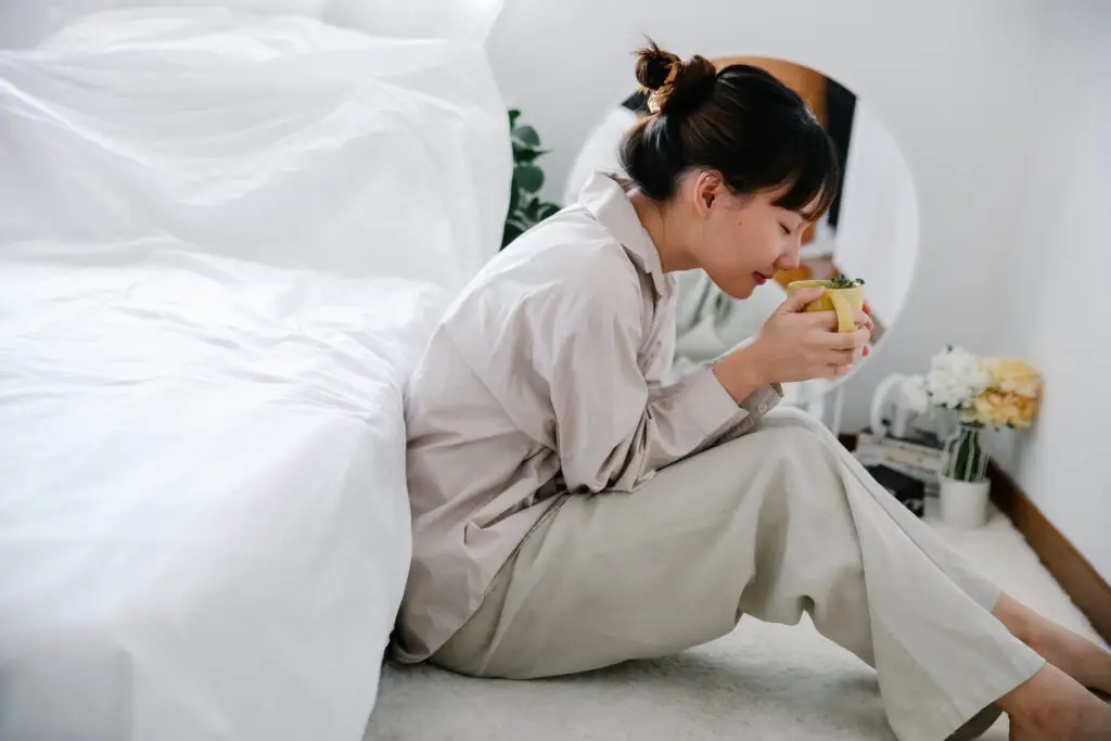 Mujer joven en pijama bebiendo infusión
