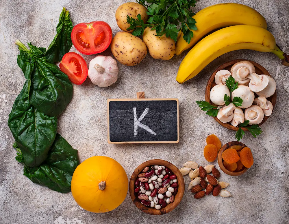 vitamina k variedad de alimentos y letrero en el centro con letra k
