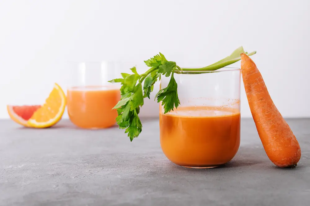 zanahoria vaso con jugo anaranjado y vegetales